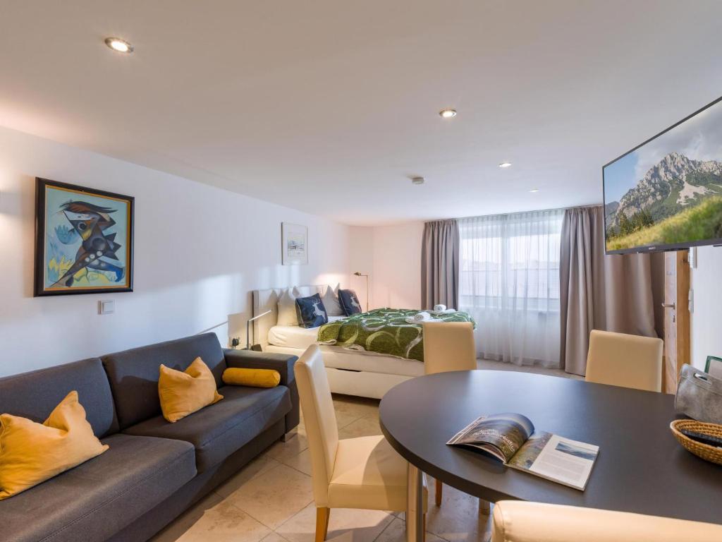 a living room with a couch and a table and a bed at Garten Suite mit 2 separaten Studios in Kirchberg in Tirol