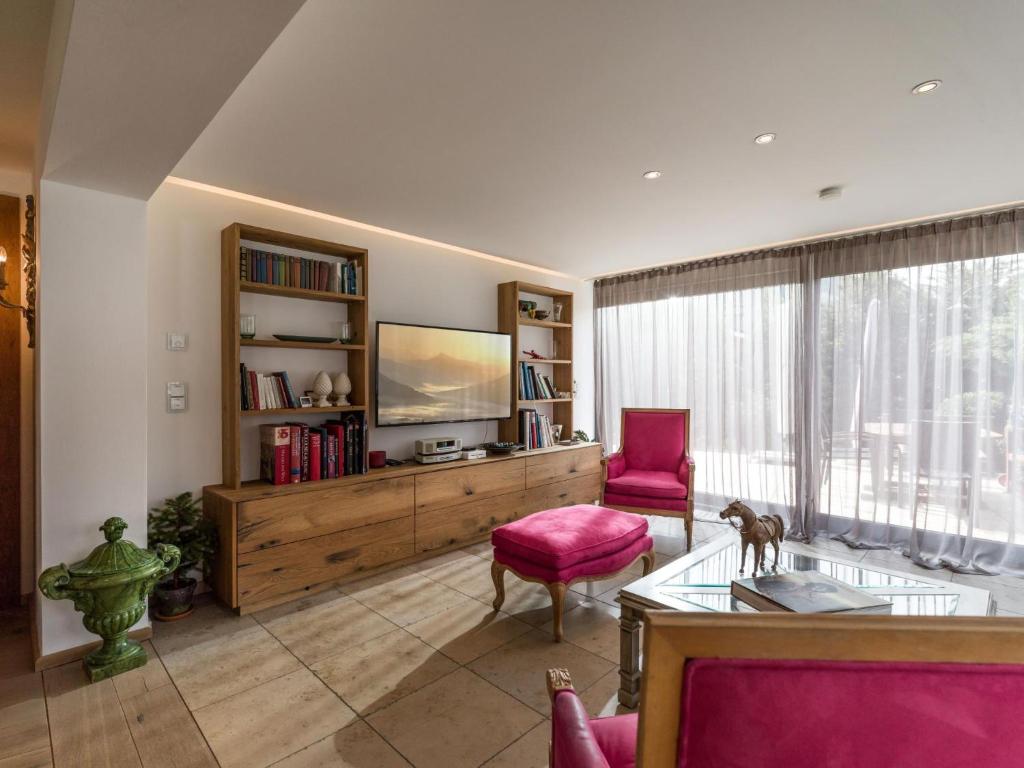 a living room with a television and a table and chairs at Exclusive Garden Suite in Kirchberg in Tirol