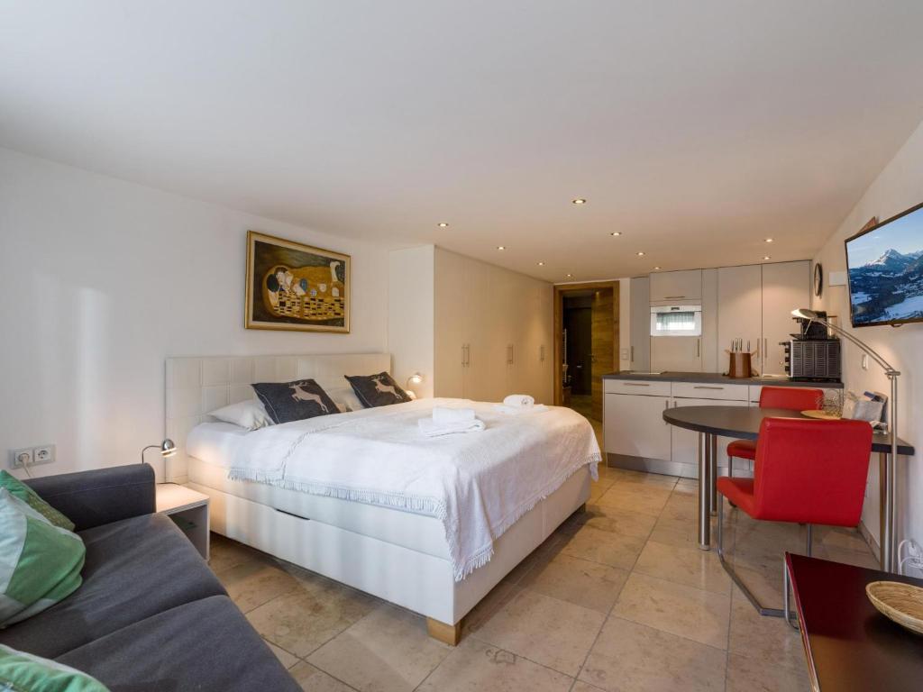 a bedroom with a bed and a table and a kitchen at Studio mit Sauna in Kirchberg in Tirol