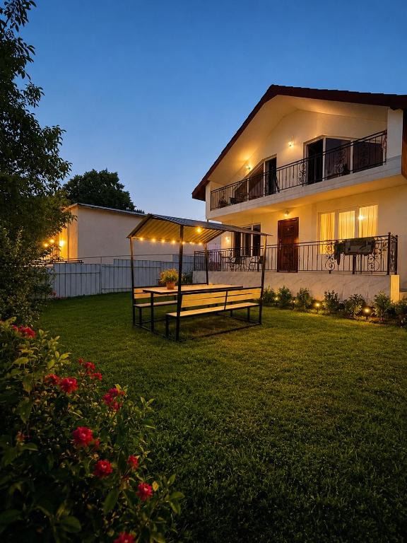 a house with a group of benches in the yard at cottage in tsemi (Borjomi) in Borjomi