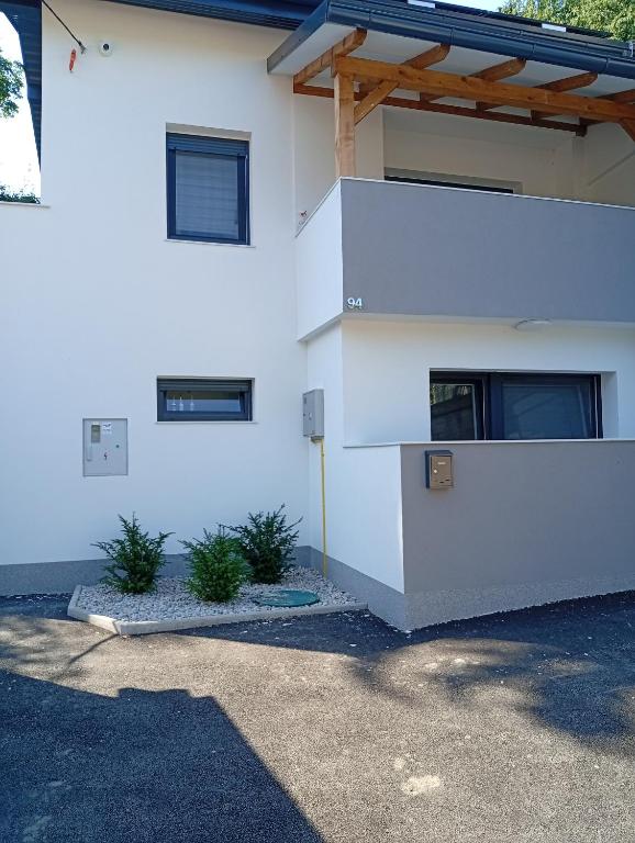 a white house with a wooden roof at Studio apartman Topolovec in Krapina