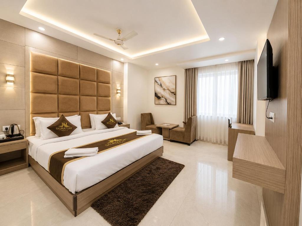 a hotel room with a large bed and a television at Hotel Bellwood Inn Near IGI Delhi International Airport in New Delhi