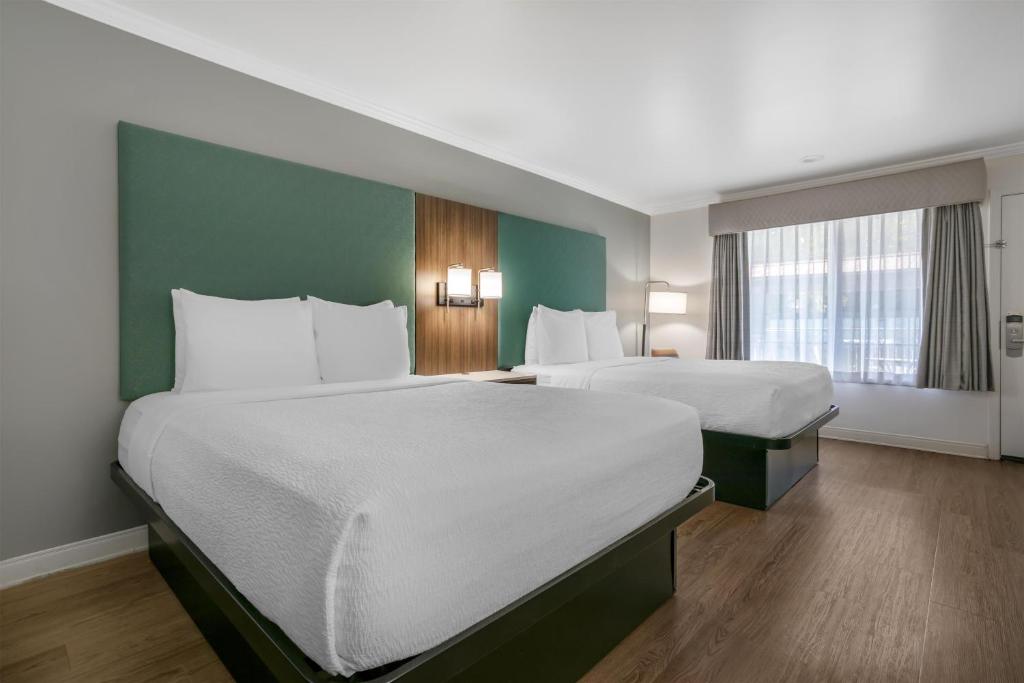 a hotel room with two beds and a window at Best Western Plus Riviera in Menlo Park