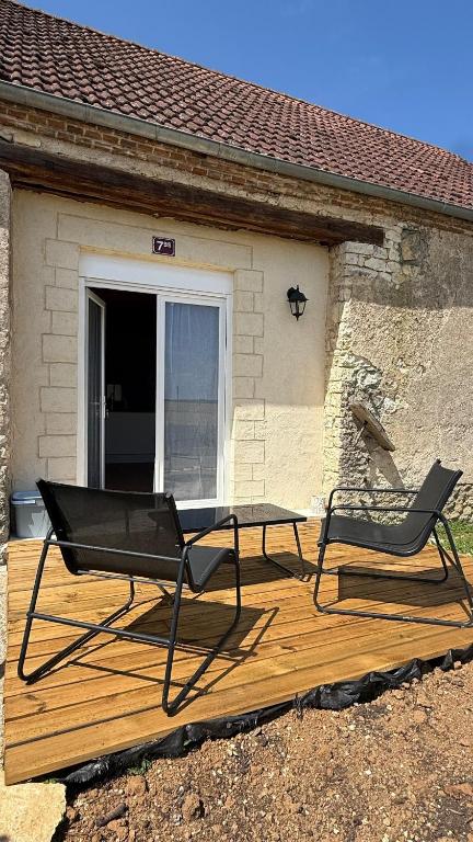 two chairs and a table on a wooden deck at Maison de Campagne 