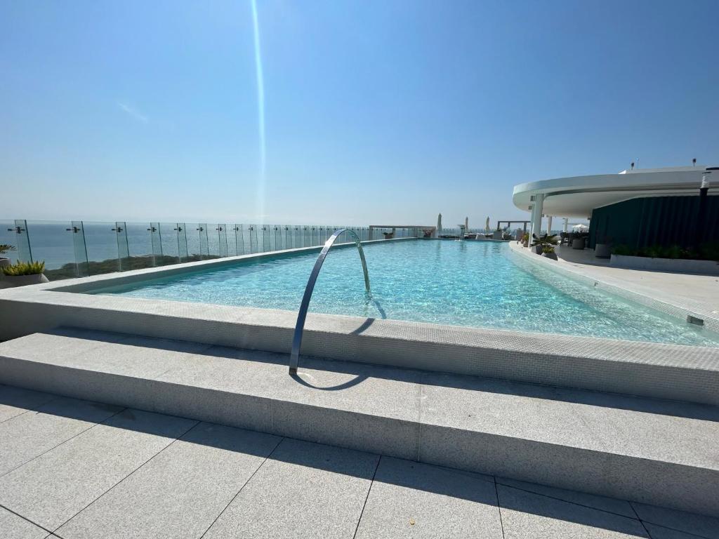 a swimming pool with a hose in front of a building at Departamento Brisa del Mar Punta Mita, Beach Front in Bucerías