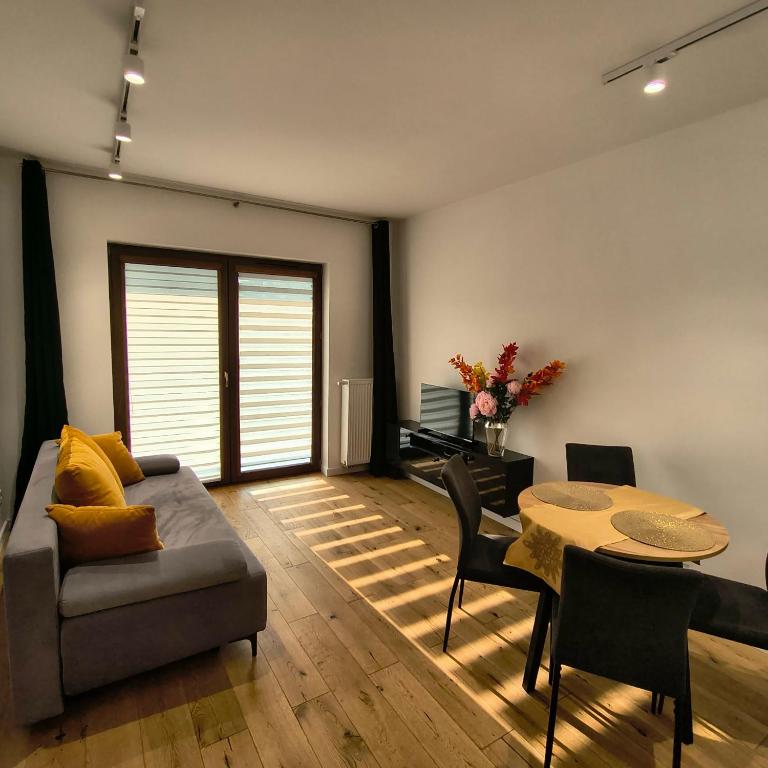 a living room with a couch and a table at Apartament Matki Polki I in Łódź