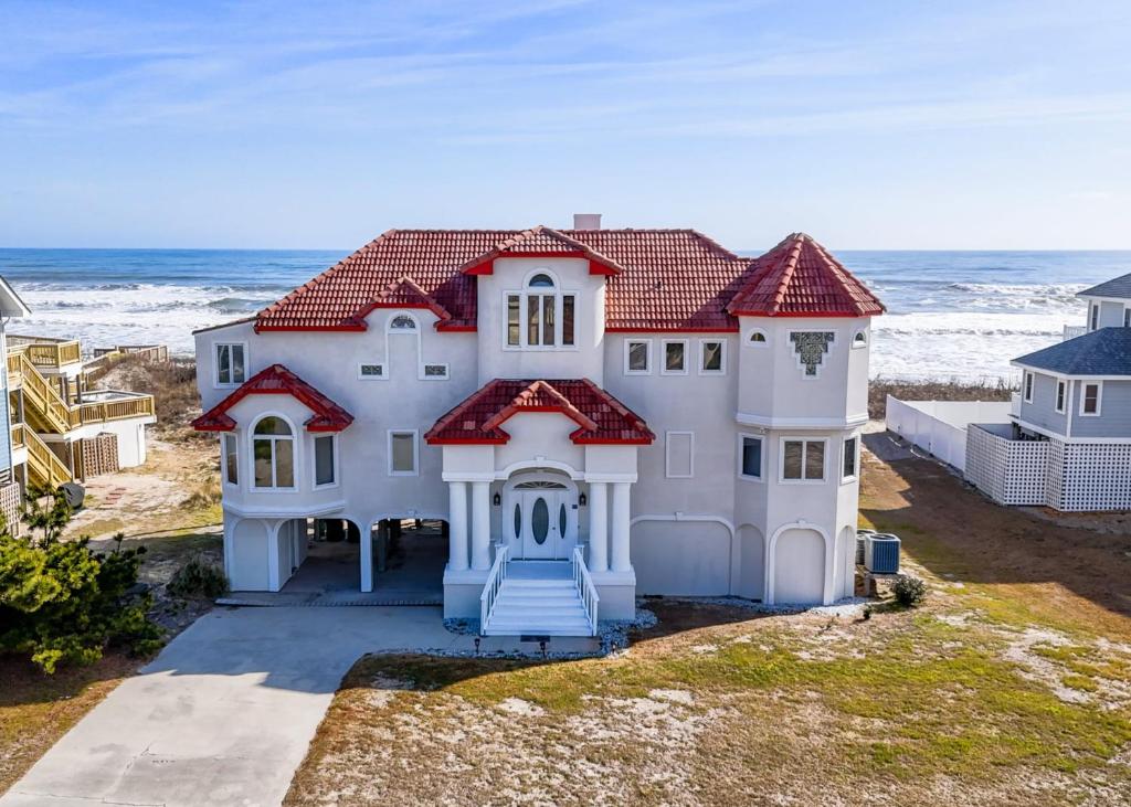 a large white house with the ocean in the background at 1026 - Carpe Diem in Corolla