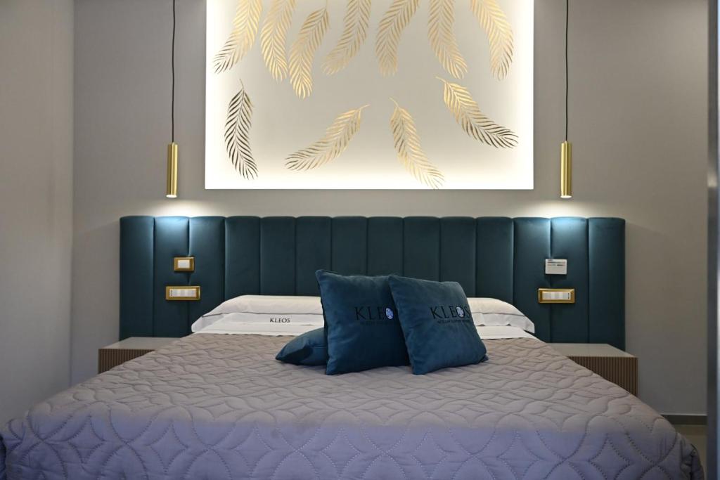 a bedroom with a bed with a blue head board at Kleos Luxury Rooms in Porto Empedocle