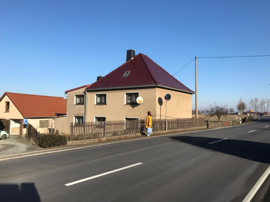 a person standing next to a house on the side of a street at Landhaus Oma Gretel - Nossen, Siebenlehn, Freiberg, Meißen, Dresden, Chemnitz 