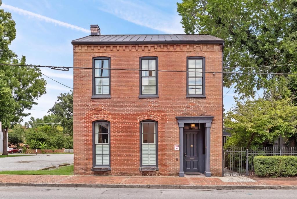 an old red brick building with a black door at The Germantown Inn in Nashville
