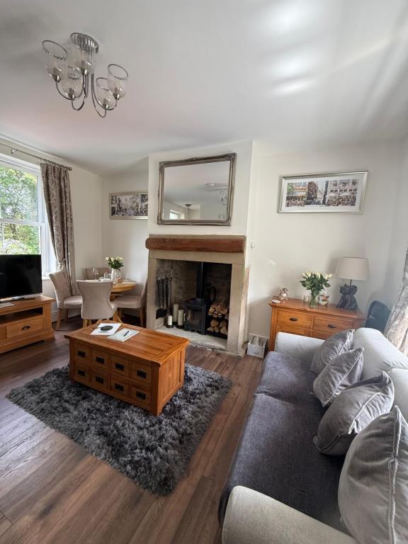 a living room with a couch and a fireplace at Wallnook Cottage Luxury Yorkshire Escape in Lindley