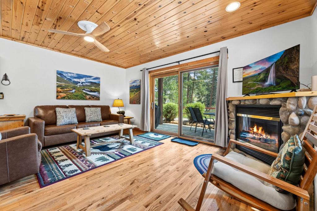 a living room with a fireplace and a couch at Bugle Pointe B06 by Estes Park Condos in Estes Park