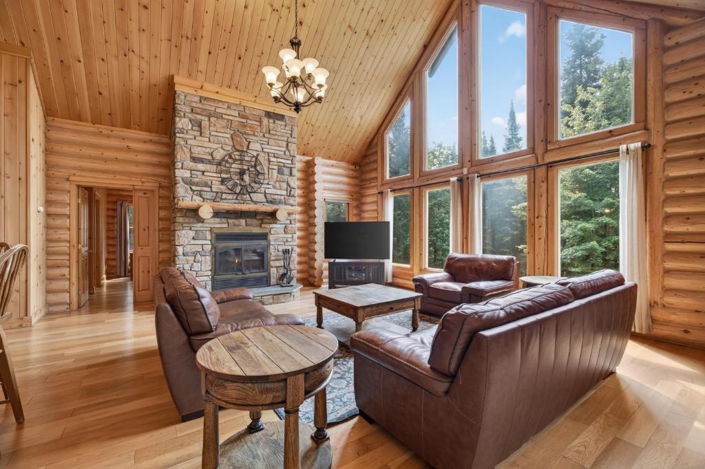 a living room with leather furniture and a fireplace at Fiddler Lake Resort - Deer 48 in Mille-Isles