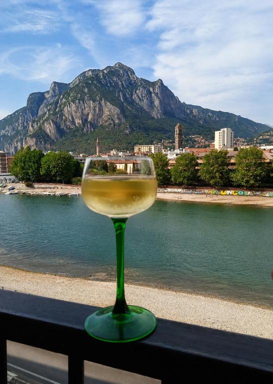 a glass of wine sitting on a table near the water at La Dolce vista, Lecco apartment with lake view in Malgrate