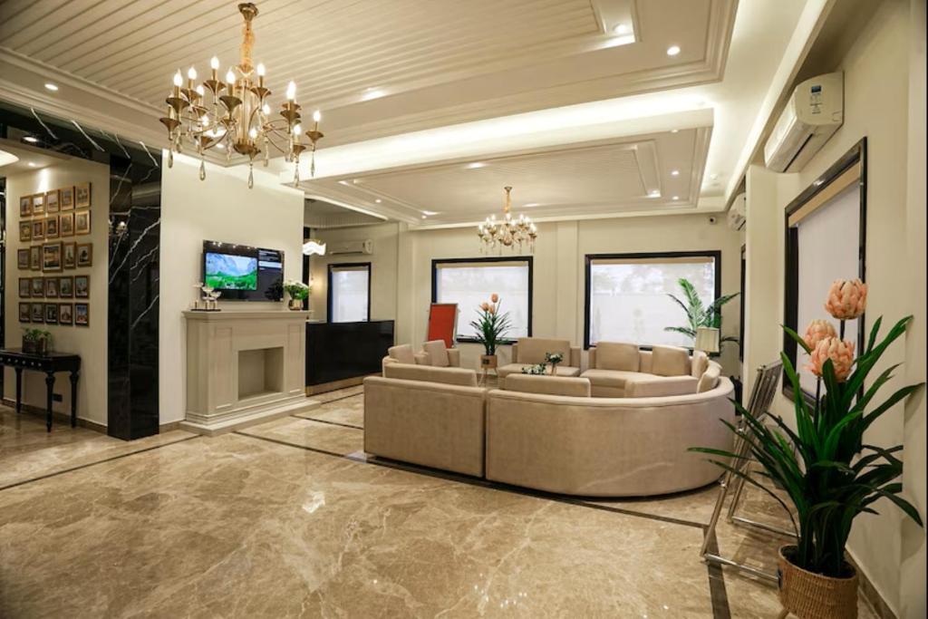 a lobby with a couch and a tv in it at The ELET near Amritsar Airport in Amritsar