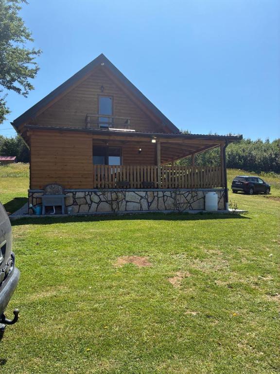 a log cabin with a large deck in the yard at Planinski Kutak in Vareš