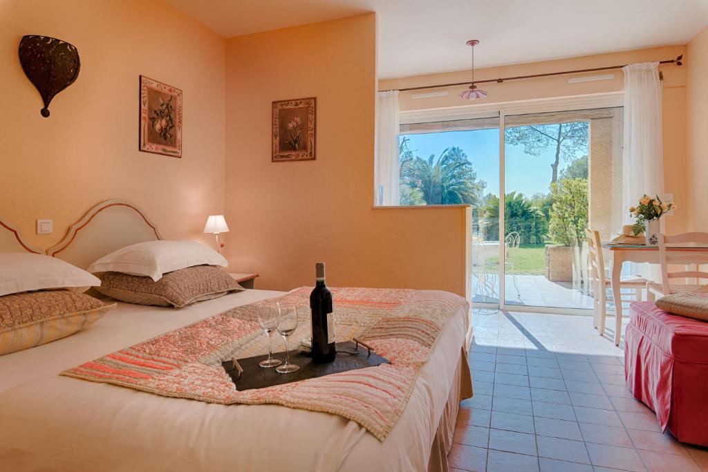 a bedroom with two beds with wine glasses and a window at La Résidence du Moulin in Tourrettes-sur-Loup