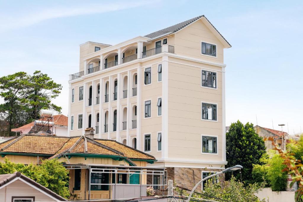 a large white building with a roof at DO Hotel in Da Lat