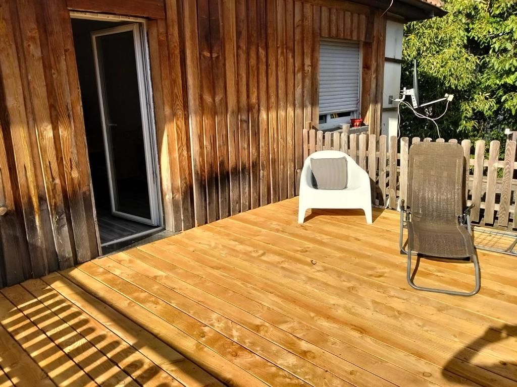 eine Holzterrasse mit einem Stuhl und einem Stuhl in der Unterkunft Welschbach in Illingen