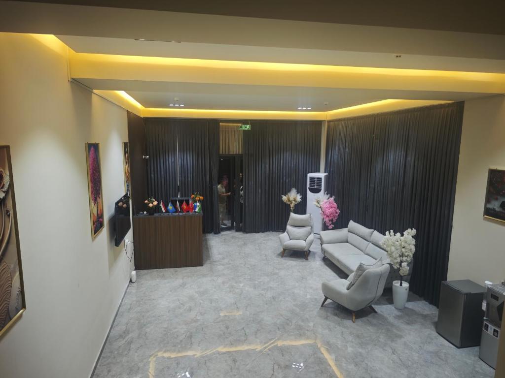 a living room with a couch and two chairs at Baxt Hotel&Hostel in Andijan