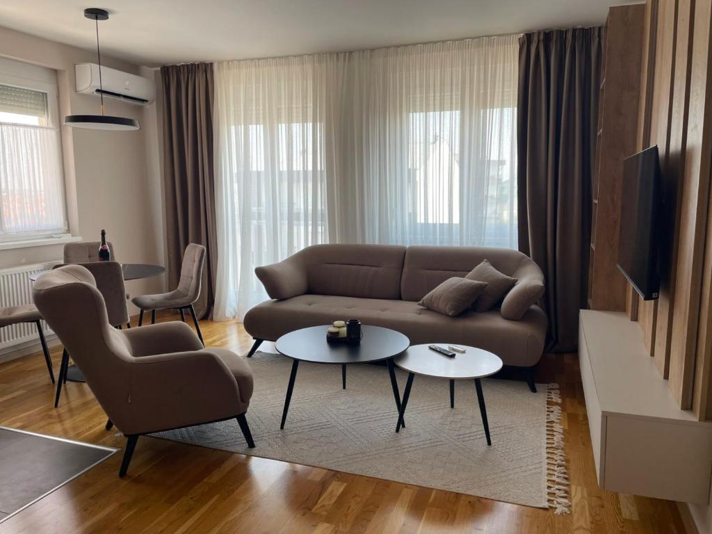 a living room with a couch and two tables at Apartman Laki in Bijeljina