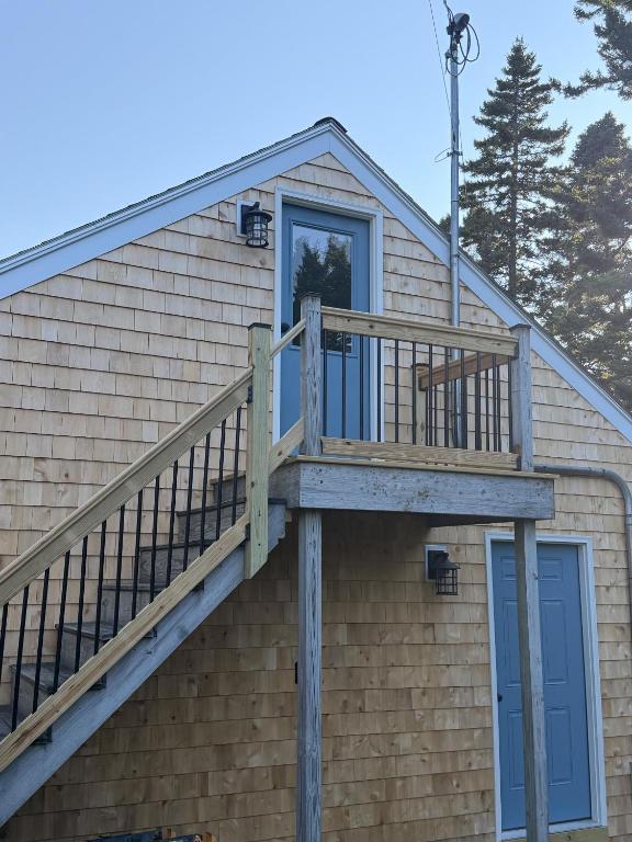 a deck on the side of a house at Capstone Cottage - Quintessential Cabin on Bay in Gouldsboro