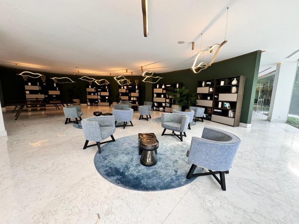 a waiting room with chairs and a table and shelves at Departamento Diamante Azul Punta Mita, Beach Front in Punta Mita