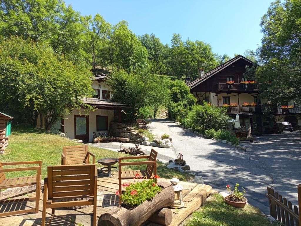 a backyard with chairs and a table and a house at Agriturismo La Gerla in Cesana Torinese