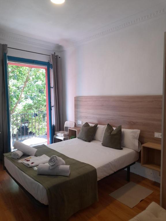 a bedroom with a large bed and a large window at Pensión Bandrés Huesca Centro in Huesca