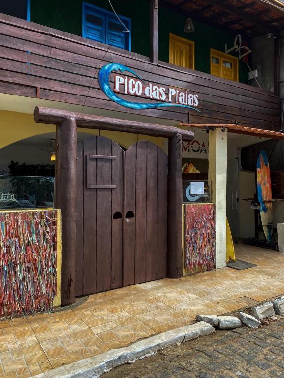 a fico has plates sign on a building with a door at Pico das Praias Suites in Itacaré