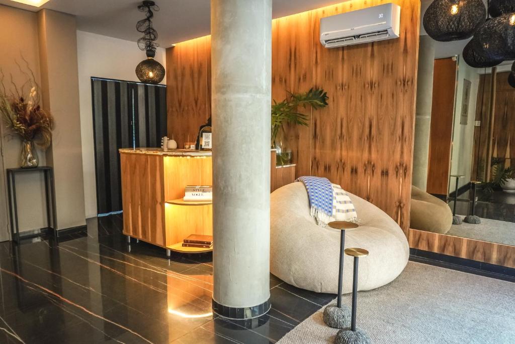 a living room with a column and a chair in a room at Aira Apart Hotel Boutique in Buenos Aires