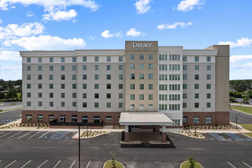 a large white building with a sign on it at Drury Plaza Hotel Mobile in Mobile