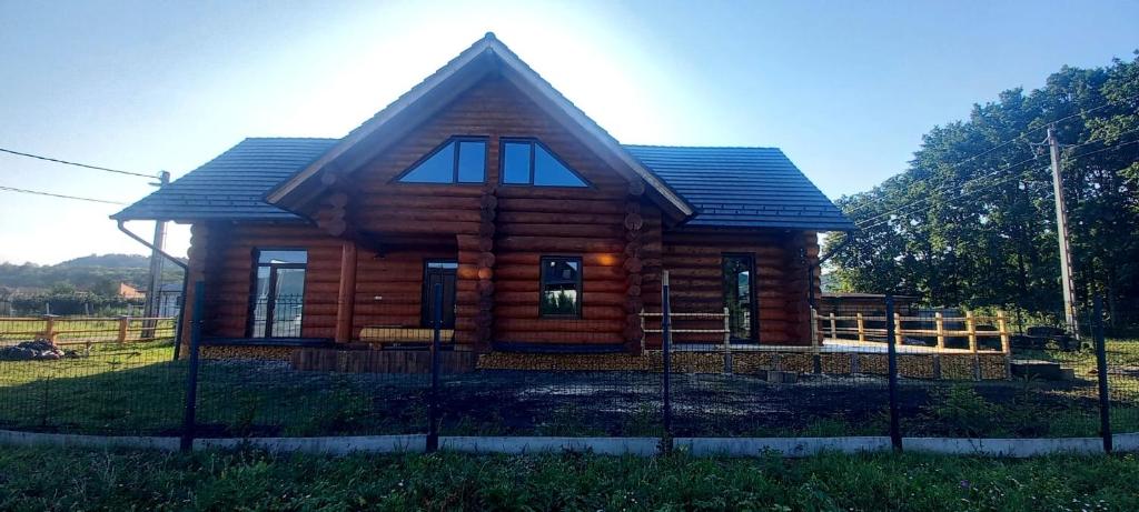 a log cabin with a fence in front of it at Rönk Villa Demjèn in Demjén