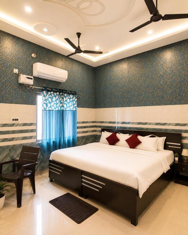 a bedroom with a large bed with blue walls at Shree Ram Mandir 500m Walk - Atharav Palace in Ayodhya
