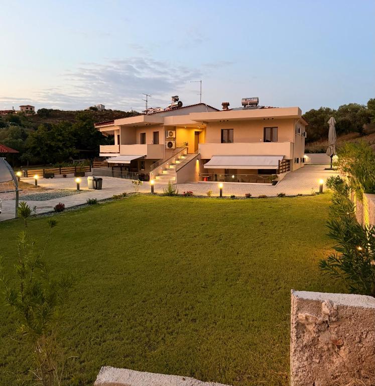 a large house with a lawn in front of it at ΝΕΑΚΙΤΟΣ Luxury Apartments in Nikiti