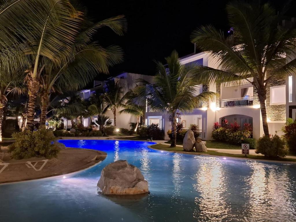 a pool at night with palm trees and a fountain at Experience the Pool View Dream at Estrella Dominicus in Bayahibe