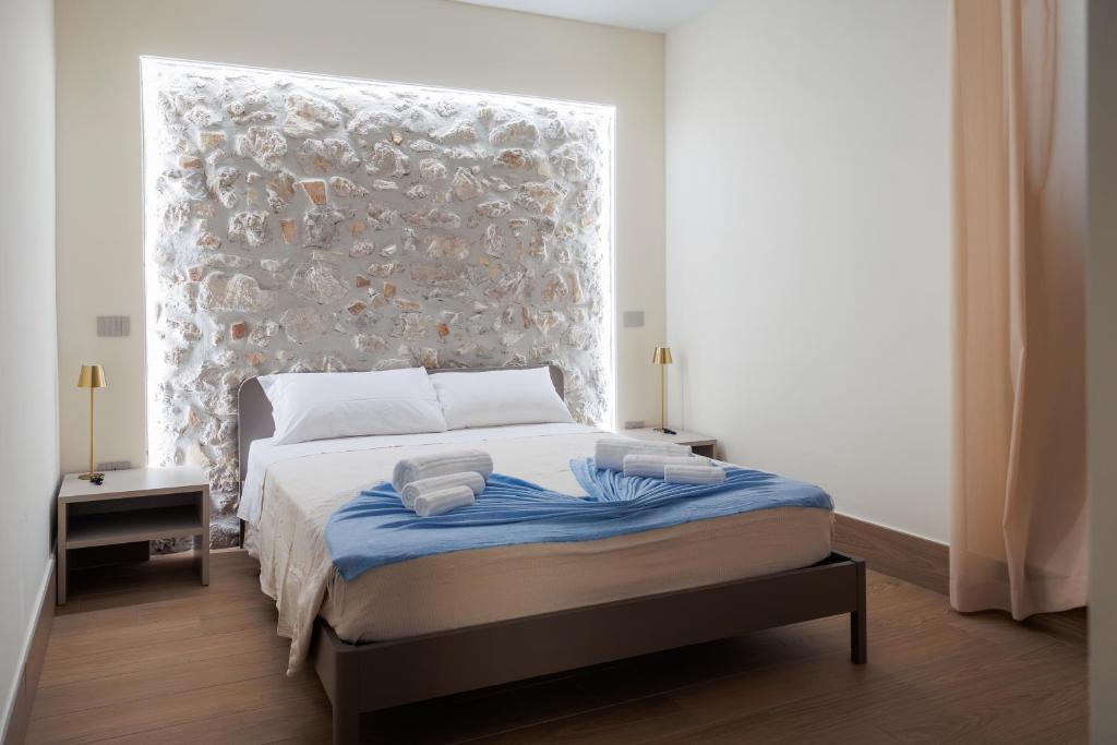a bedroom with a bed with a stone wall at B&B Alba in Celano