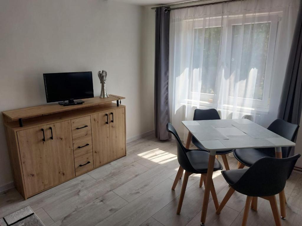 a dining room with a table and chairs and a television at Chata Rumunka in Jaroměř