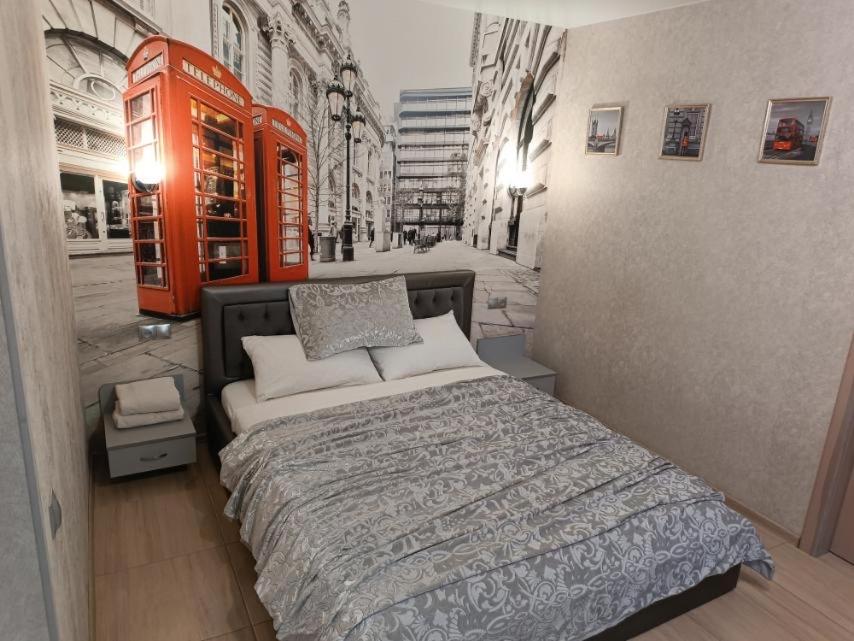 a bedroom with a bed and a red phone booth at Luxuri apartments in Chernihiv