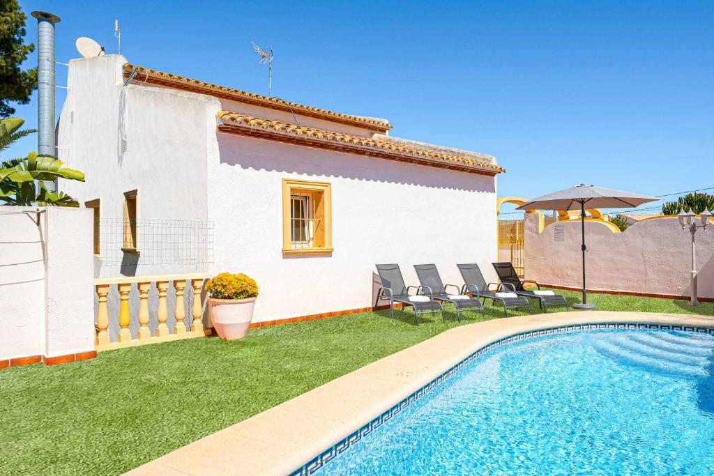 a villa with a swimming pool in front of a house at Villa Nispero in El Tosalet