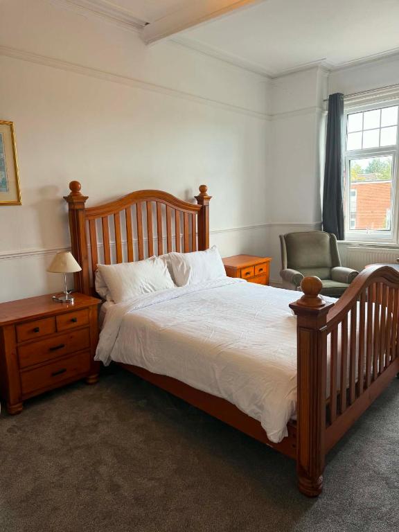 a bedroom with a large bed and a chair at The Strand Hotel in Bournemouth