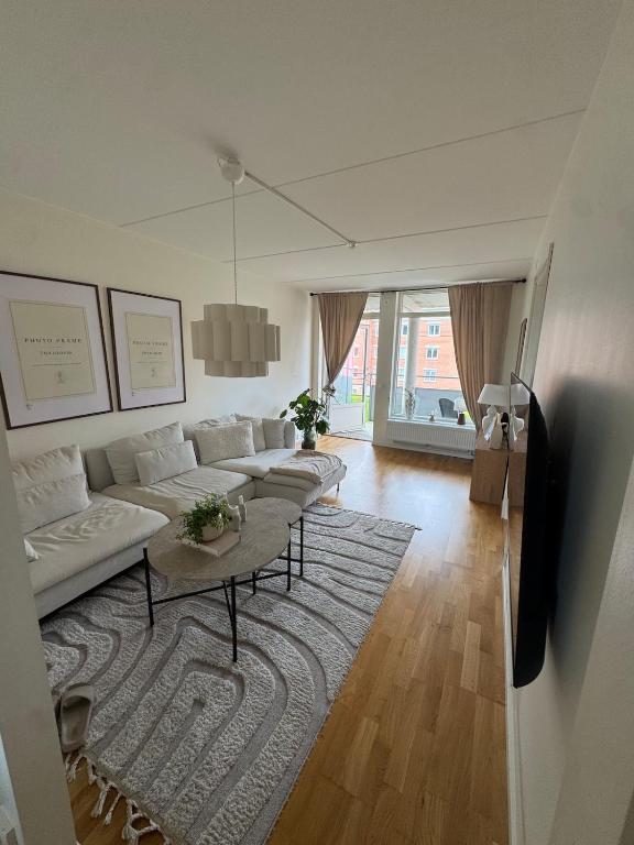 a living room with a white couch and a rug at Modern apartment with large balcony in Halmstad
