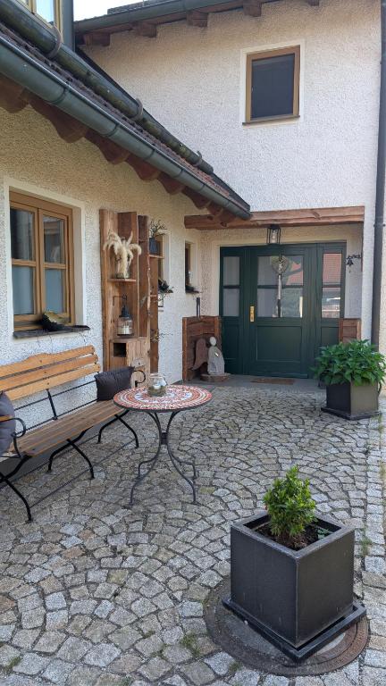 a patio with a table and a bench in front of a house at Das Fichtelgut in Wunsiedel