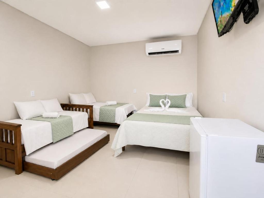 a room with three beds and a couch at Pousada Aurora Nascer do sol 1 in Manhã