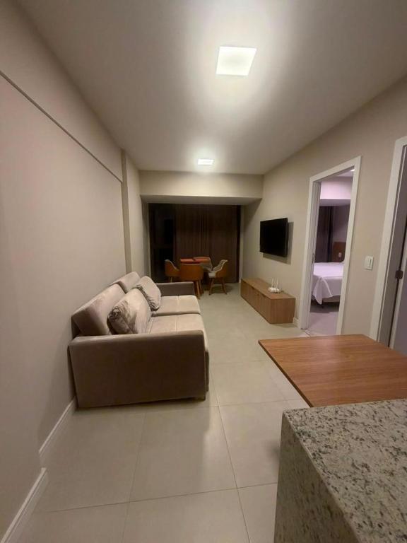 a living room with a couch and a television at View Soft House - Quarto e Sala 213 in Lauro de Freitas