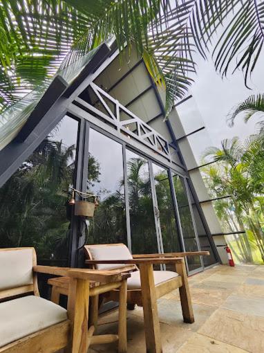 a patio with a table and two chairs and a building at LIVAA NEST Resort Mysore in Kālvādi