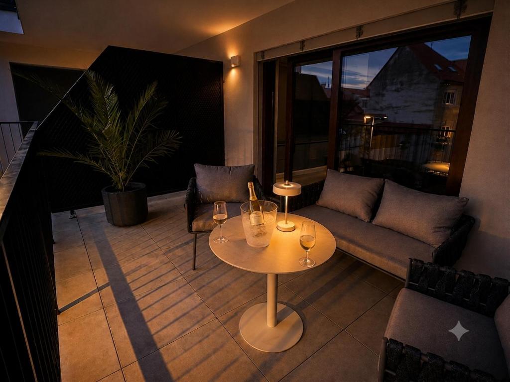 a living room with a couch and a table with wine glasses at MOOD Apartment Piešťany Centrum, parking, terasa in Piešťany