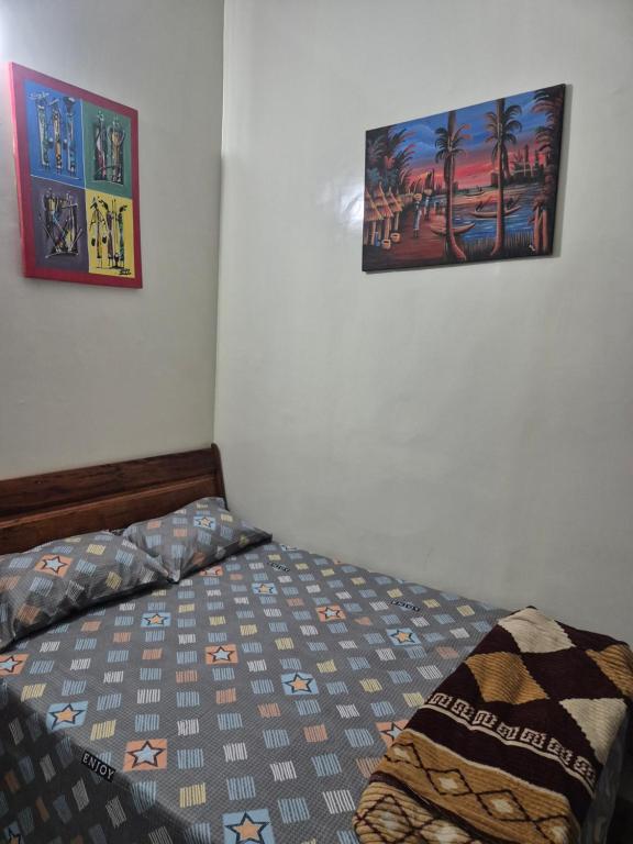 a bedroom with a bed and two pictures on the wall at SEN-HOME Free in Dakar