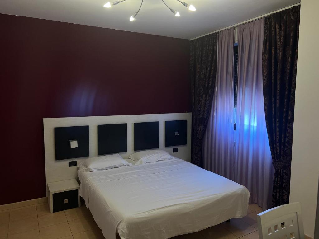 a bedroom with a large white bed with purple walls at Team Diablo Accommodations in Molinella