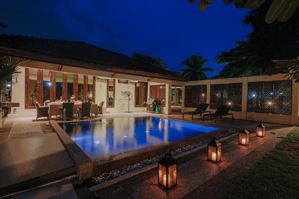 a swimming pool in the backyard of a house at night at The Villa - Private Pool near Tanjung Rhu Beach by WOW Holiday Homes in Kuah
